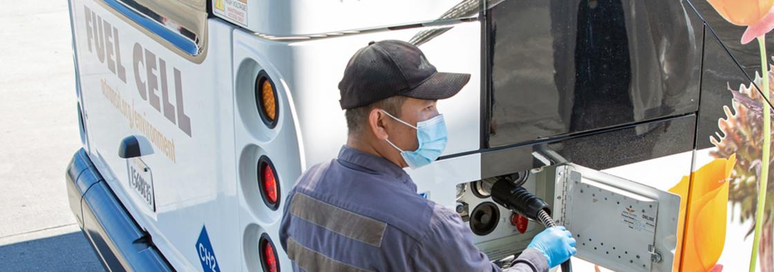 AC Transit employee charging a Fuel Cell bus