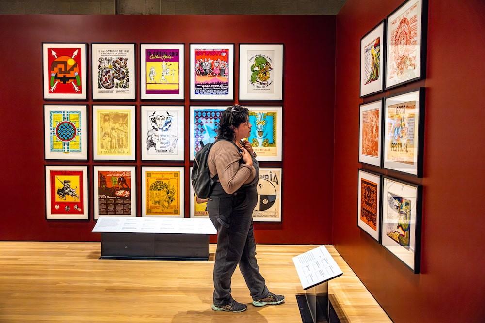 A photo of a woman walking through an art gallery at the Oakland Museum of California