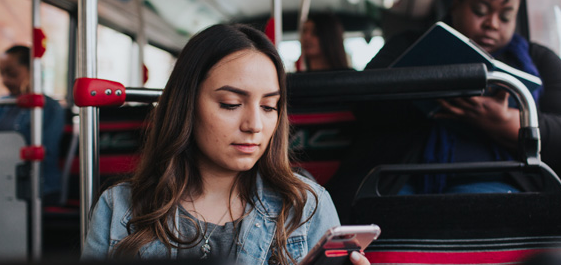 Woman on AC Transit bus looking at her phone