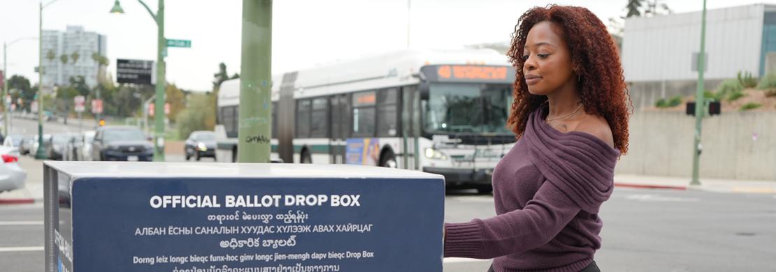 Woman dropping off voter ballot